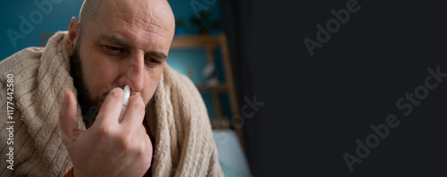 Man using nasal spray for relief at home