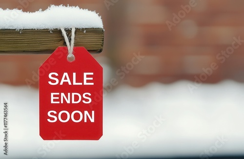 Winter sale discount exclusive concept. A red sale tag hangs from a wooden post, partially covered in snow, indicating a promotion that ends soon against a blurred background. photo