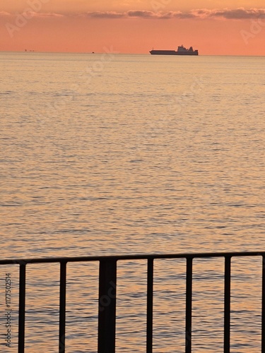 Genova, Italy - December 29, 2024: Background of beautiful sunset over Mediterranean sea waves. Selective focus. Beautiful red and orange sunrise over the sea. Beautiful seascape scenery, Amazing ligh