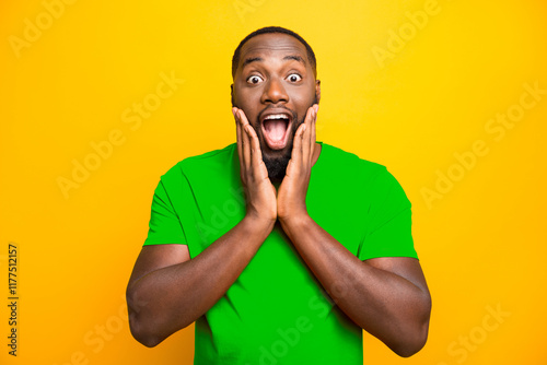 Photo of excited ecstatic rejoicing overjoyed black man admiring something adoring while isolated with yellow background photo