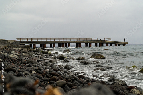 Pebble beach with pier on a cloudy day