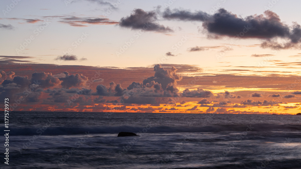 sunset over the tropical beach , orange sky sunset over the tropical beach , orange sky