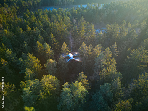 Fototapeta Naklejka Na Ścianę i Meble -  A drone flies over a forest, conducting forest inspections. This new technology enhances forest management efficiency by utilizing drones for wood management.