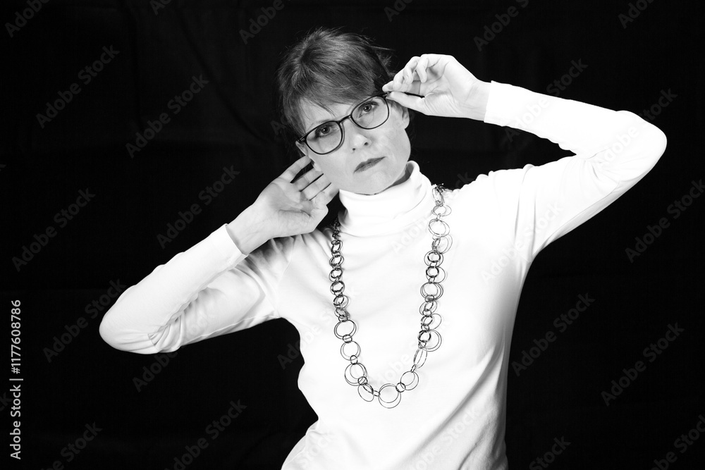 Fototapeta premium Frau mit Brille und erhobenen Armen als Schwarzweißporträt