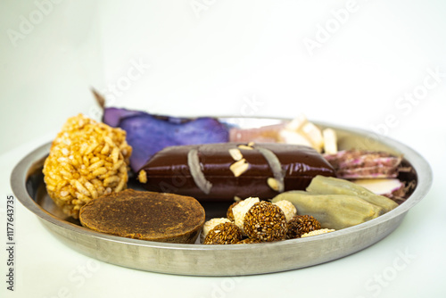 A Plate of jaggery, sesame balls, yam, sweet potato for Maghe Sankranti Festival or Pre Workout Meal photo