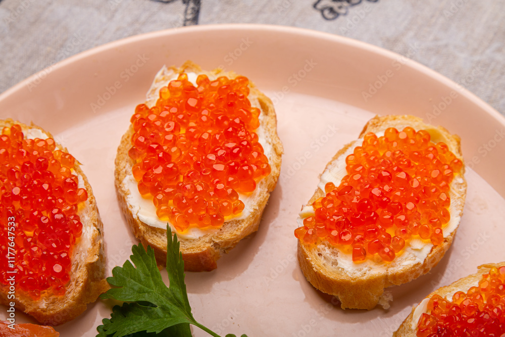 Canapes with red caviar and salted salmon on a plate decorated with cilantro Canapes with red caviar and salted salmon on a plate decorated with cilantro