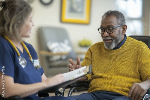 Elderly African patient in wheelchair talking to nurse in medical facility photo