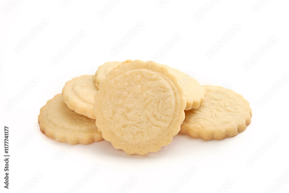Pile of butter cookies. Multiple round French cookies also known as  Parisian butter cookies, soleils or sablés. Tea biscuit or for holiday gifting. Selective focus. White background.