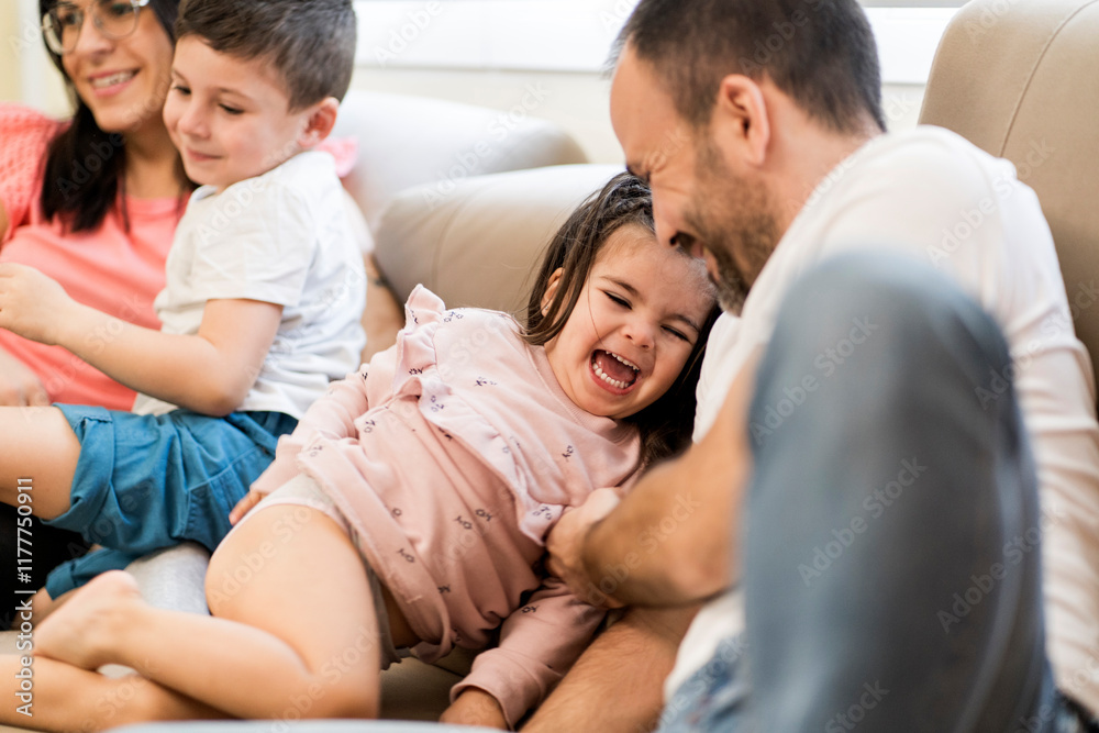 Happy family playing together on sofa Happy family playing together on sofa