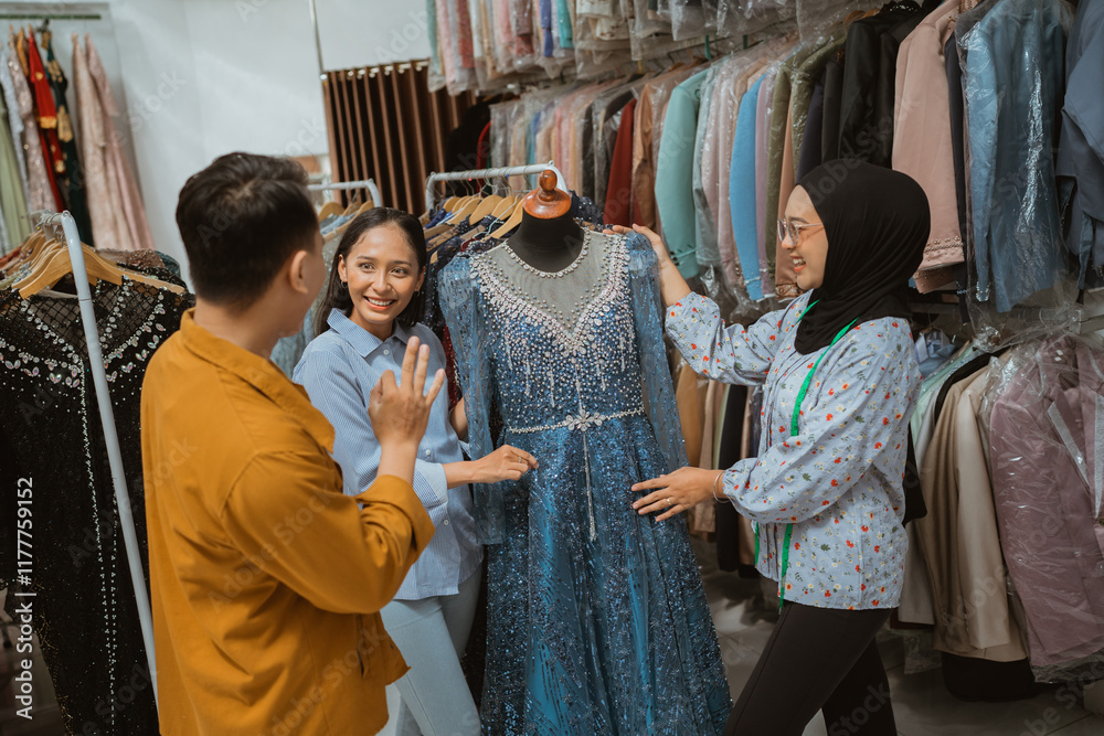 Three close friends happily browse and admire a stunningly beautiful blue dress in a boutique store Three close friends happily browse and admire a stunningly beautiful blue dress in a boutique store
