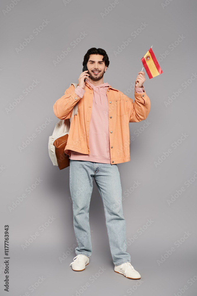 Young man celebrating with a flag while talking on the phone in a creative studio setting Young man celebrating with a flag while talking on the phone in a creative studio setting
