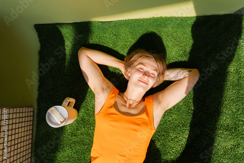 Woman laying on fake grass sunbathing  photo