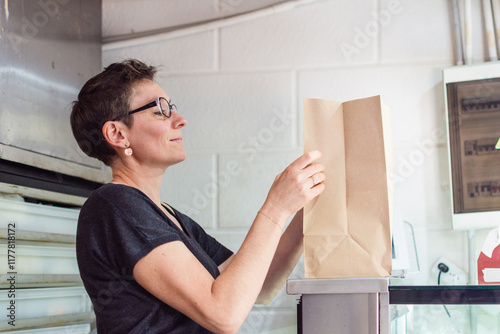 Takeout window clerk putting products in paper bag photo