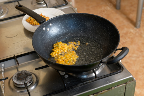 Indonesian Corn Fritters Bakwan Jagung cooking in the pan photo