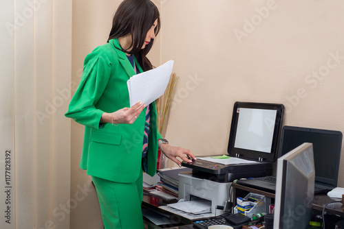 Woman in suit making copies of documents in office photo