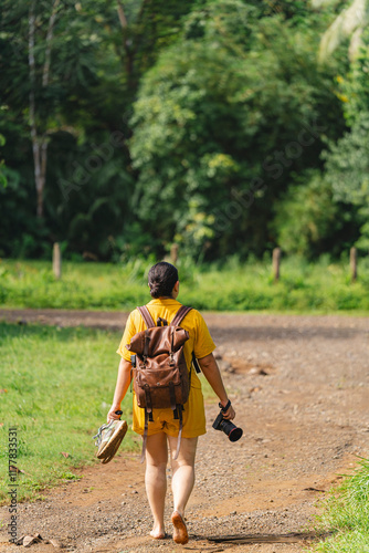 Photographer woman walking without shoes on a stone path photo