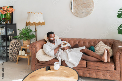 Man With Eye Patches Caressing His Dog On Sofa photo