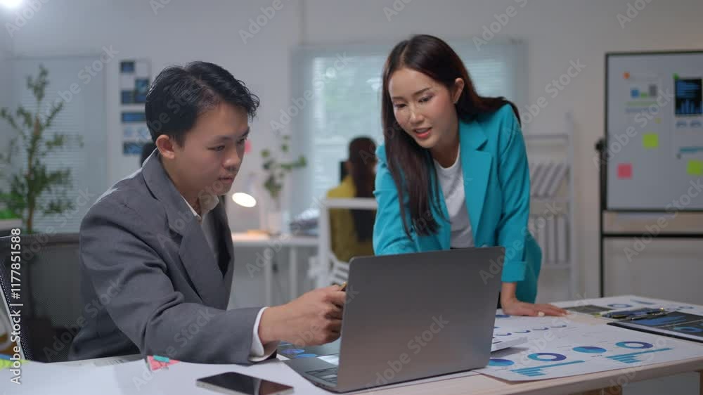 Business partners analyzing project data on laptop, collaborating with focused teamwork in contemporary corporate workspace Business partners analyzing project data on laptop, collaborating with focused teamwork in contemporary corporate workspace