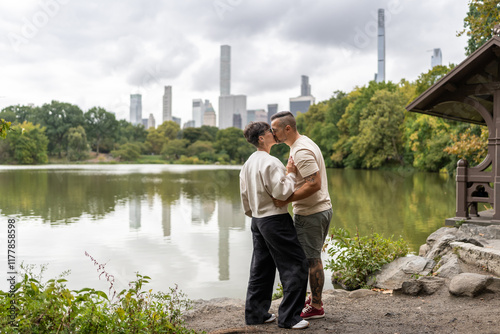 Couple kissing in central park with new york city skyline photo