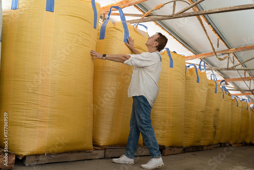 Senior Worker Engaged in Industrial Inspection of Large Storage Bags photo