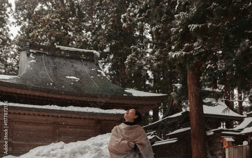 A Woman Joyfully Admiring Falling Snowflakes. photo