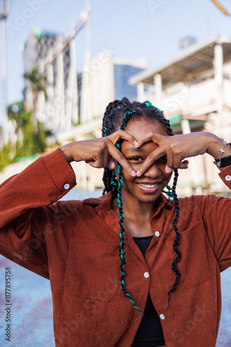 Happy young woman making heart shape gesture photo