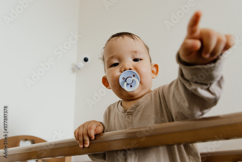 A baby in a crib with a pacifier