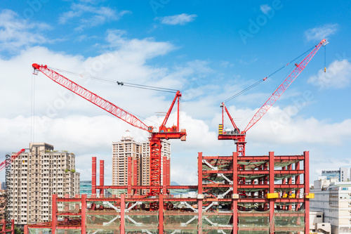 Red Cranes at Construction Site Under Blue Sky photo