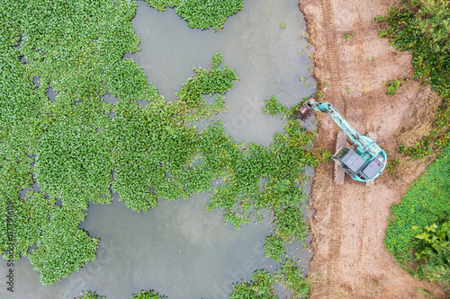 Excavator Removing Water Hyacinth from Pond