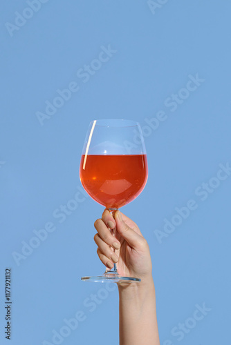 Holding a glass of red wine separately on a purple background photo