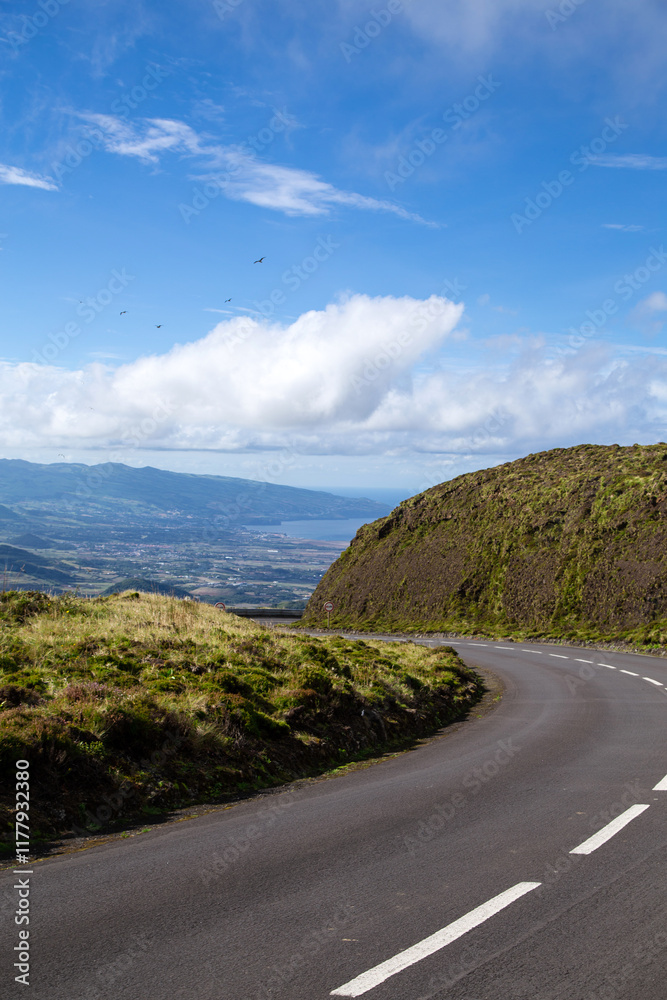 Scenic winding road through lush hills on a sunny day Scenic winding road through lush hills on a sunny day