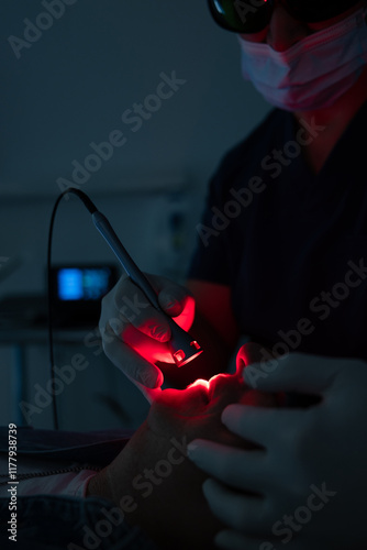 Dentist performs advanced dental procedure with laser tool photo