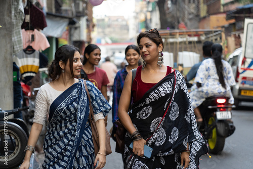 Women are walking through a busy road of a metro city photo