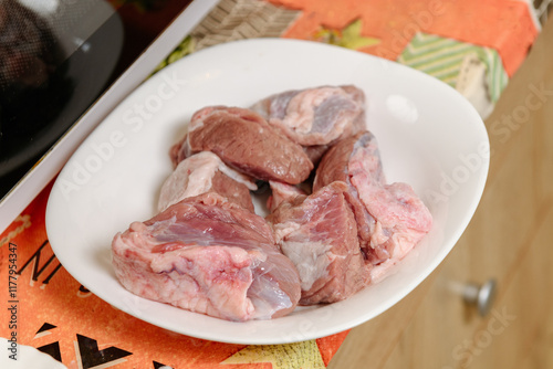 Raw lamb meat cuts on a white plate