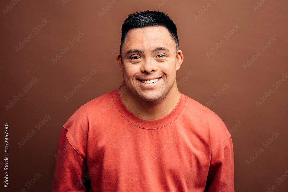 Man with Down syndrome smiling on brown background Man with Down syndrome smiling on brown background