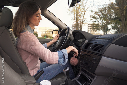 Obraz na płótnie Young woman starting or stopping car engine with key w salonie