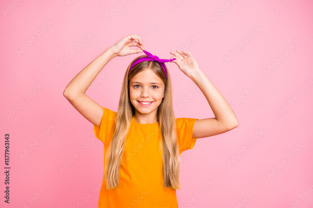 Close-up portrait of her she nice-looking attractive lovely winsome cheerful cheery pre-teen girl wearing yellow t-shirt fastening head band isolated over pink pastel background Close-up portrait of her she nice-looking attractive lovely winsome cheerful cheery pre-teen girl wearing yellow t-shirt fastening head band isolated over pink pastel background