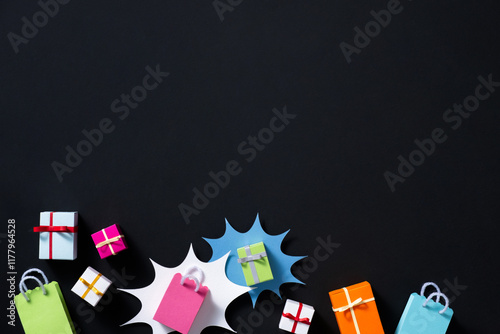 Colored gift boxes and shopping bags arranged on a black background photo