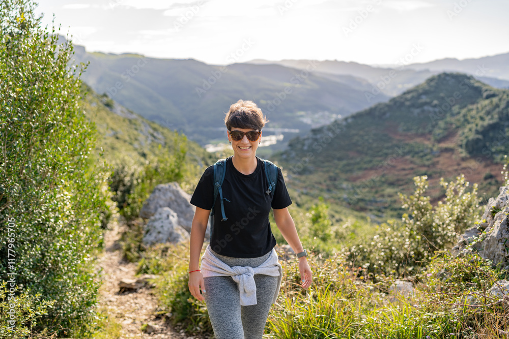 Hiker walking on a mountain path enjoying the view Hiker walking on a mountain path enjoying the view