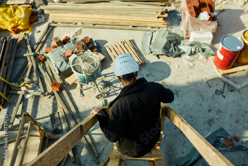 Construction site manager comes down the scaffolding