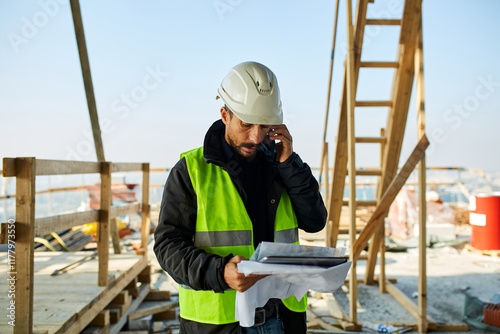 Construction site manager talks on the phone