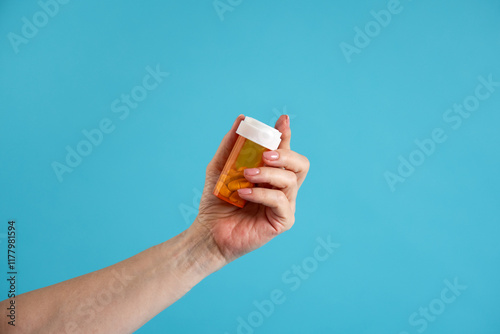Hand holding prescription pill bottle. 