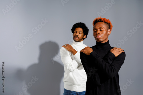 Two men pose elegantly with eyes closed photo