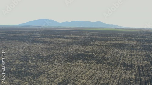 Aerial drone video of plowed agricultural field in the  winter time with mountains in the background