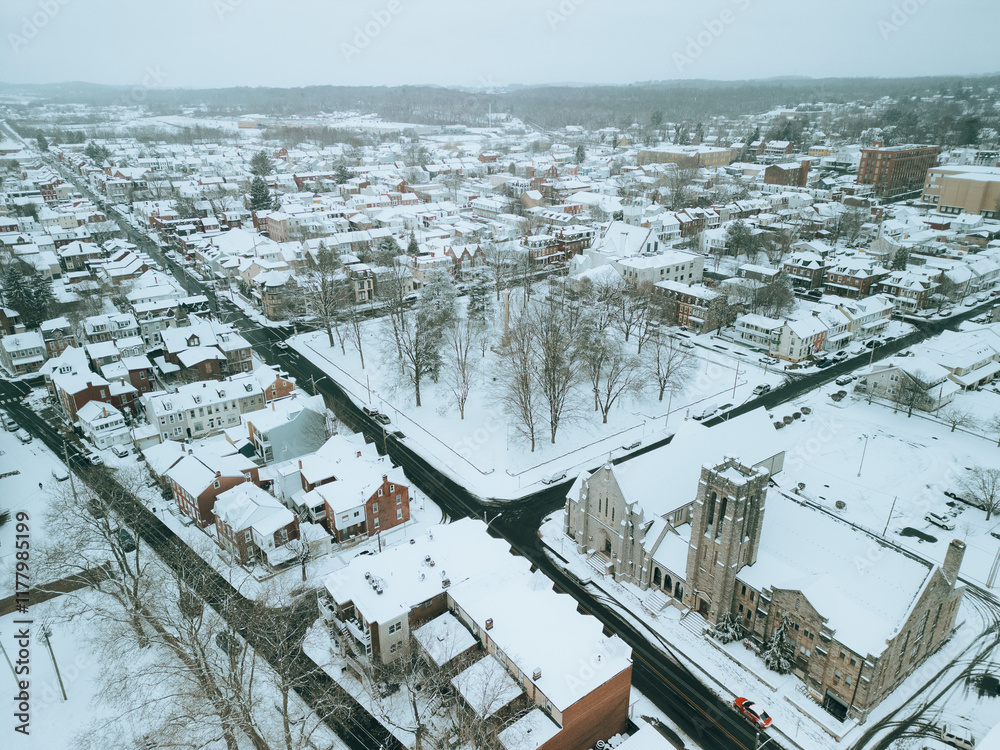 Fototapeta premium Aerial drone view of small town during a snow storm. Cinematic look.