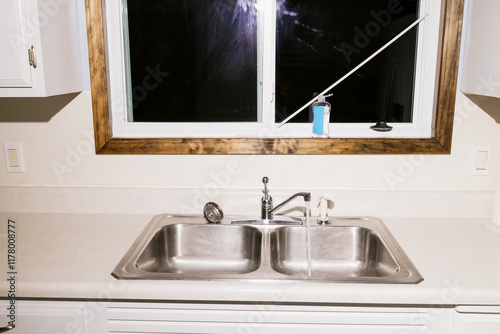 sink with running water in empty kitchen photo