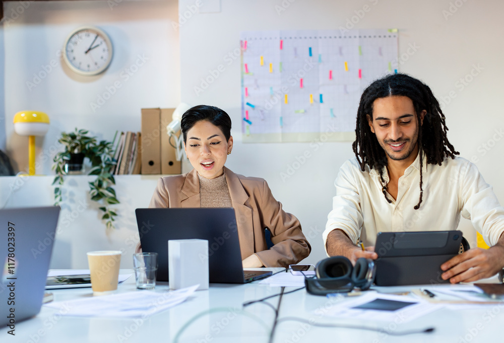 Diverse Coworkers discussing project in office Diverse Coworkers discussing project in office