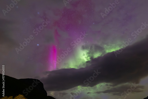 The stunning Northern Lights over Lofoten Islands, Norway, with vivid colors lighting up the night sky above mountains. photo