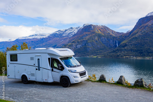 A motorhome parked by the serene Lustrafjorden in South Norway, with stunning mountains and a waterfall in the background. photo