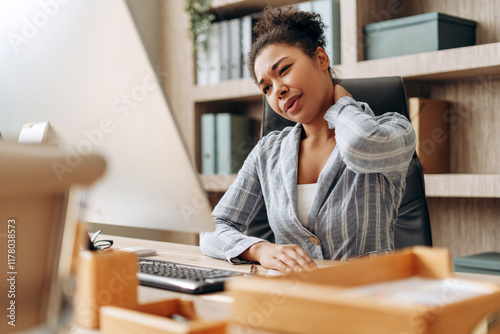 Office worker suffering neck pain at work using computer photo